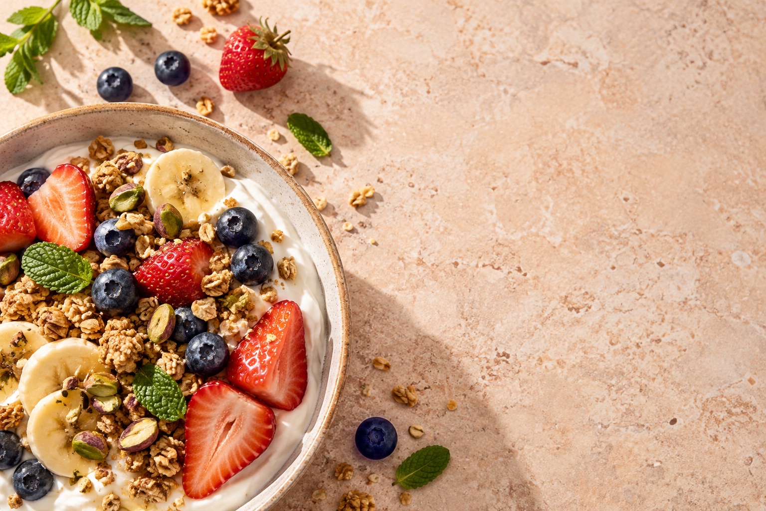 Yogurt breakfast with berries, banana, granola and mint
